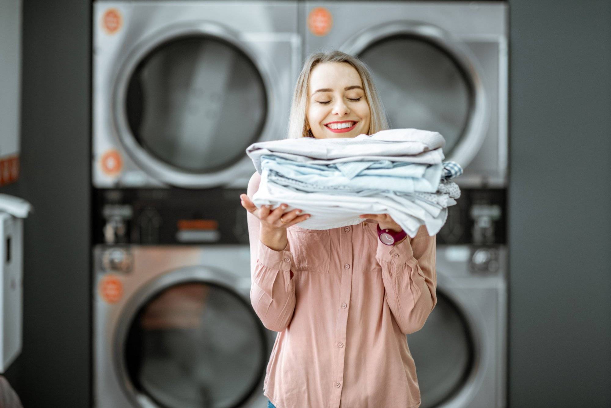 Woman with ironed clothes in the laundry Woman with ironed clothes in the laundry