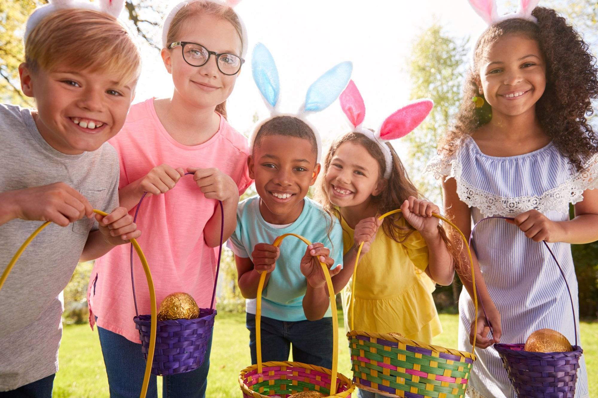 Portrait Of Five Children Wearing Bunny Ears On Easter Egg Hunt In Garden Portrait Of Five Children Wearing Bunny Ears On Easter Egg Hunt In Garden