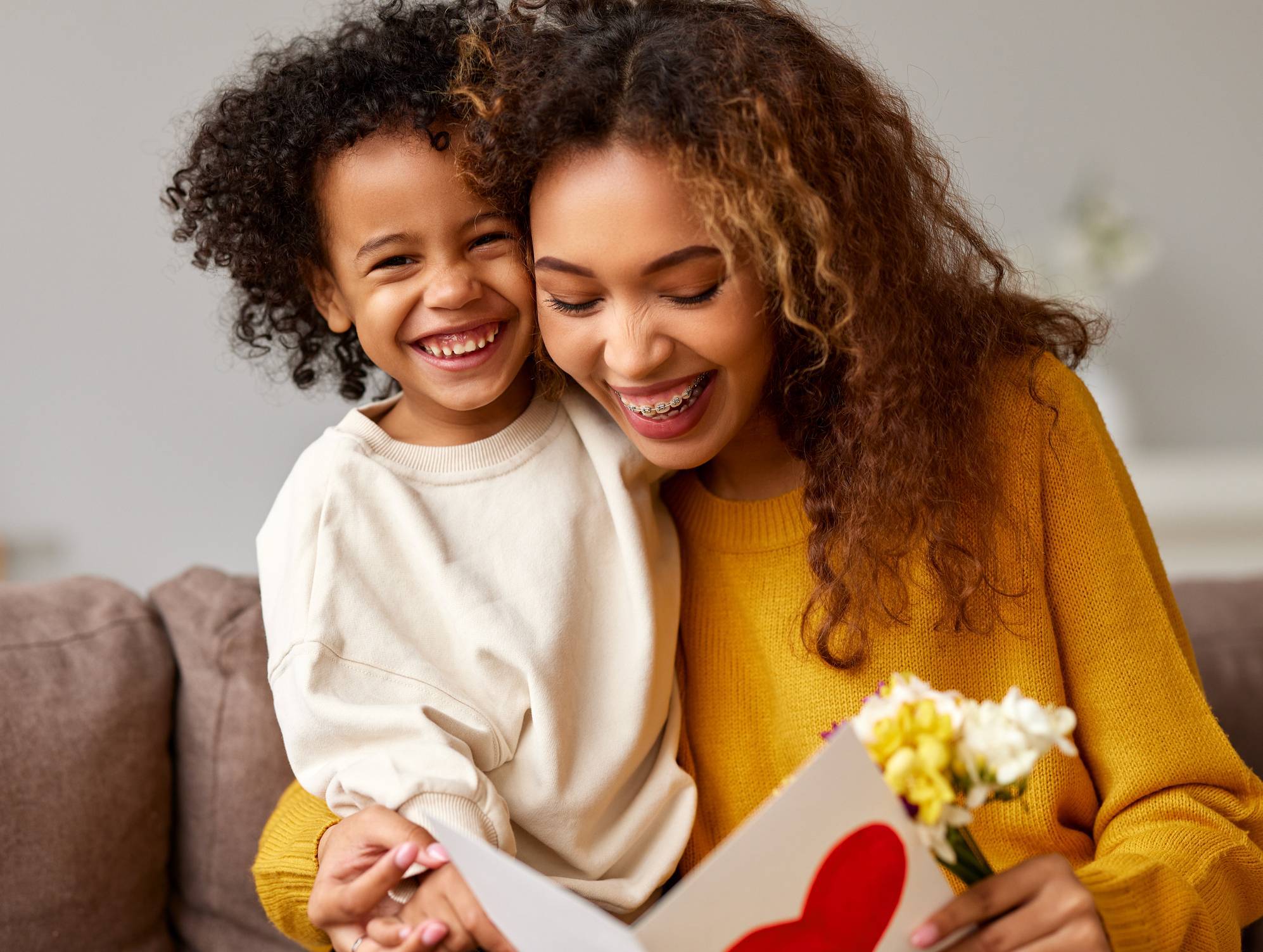 Young mixed race woman getting congratulations from son on Mothe Young mixed race woman getting congratulations from son on Mothe