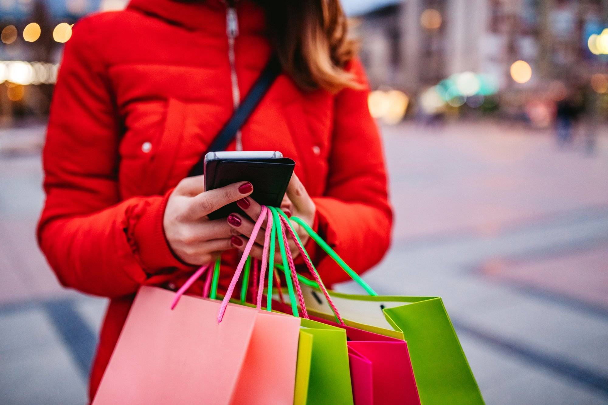 Woman with shopping bags using phone Woman with shopping bags using phone