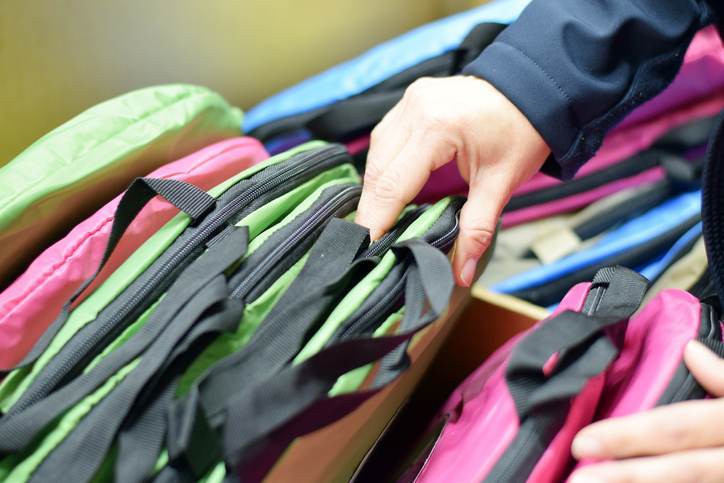 Woman’s hand shopping through backpacks Woman's hand shopping through backpacks